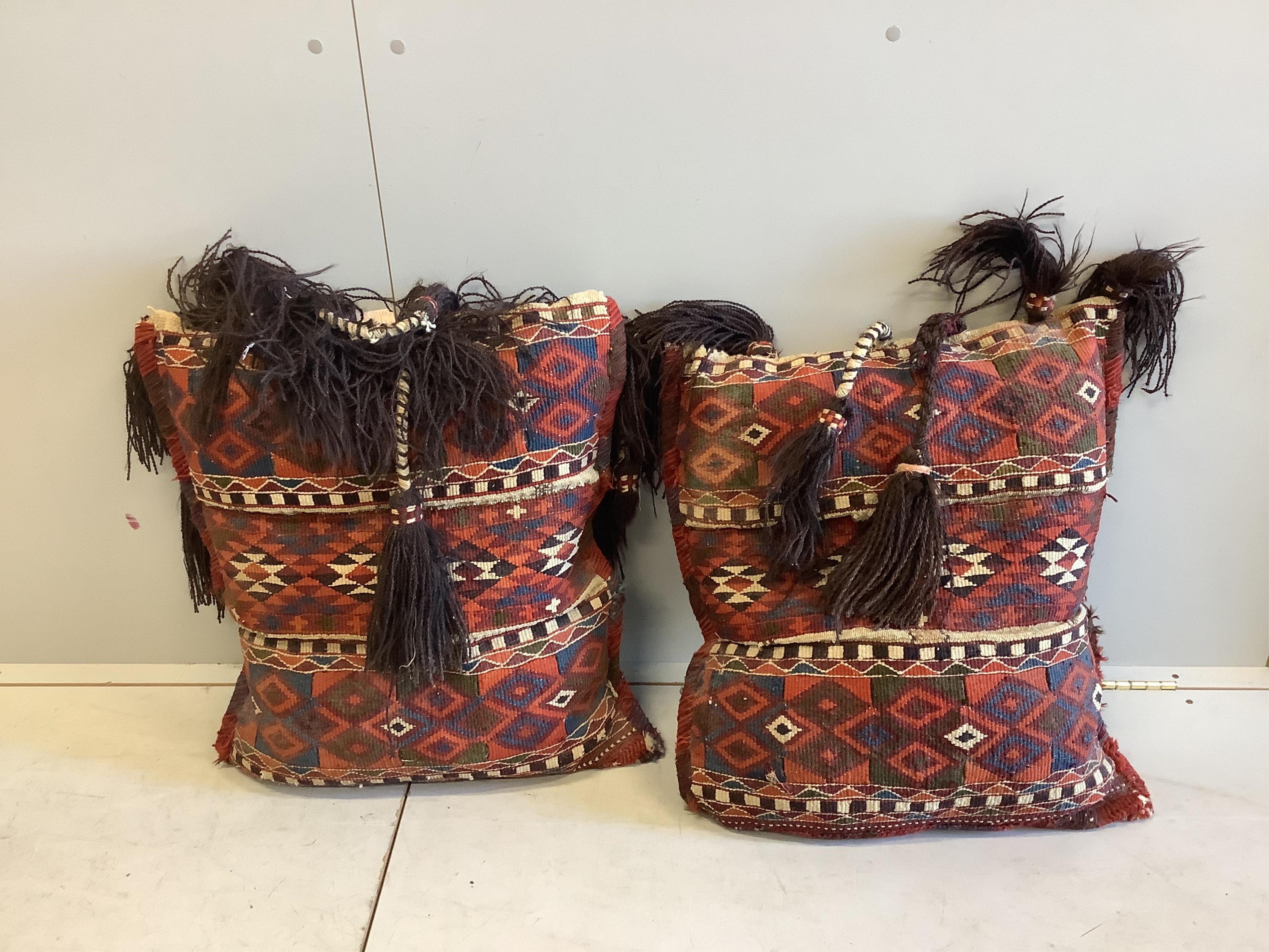 Two Kilim polychrome camel bags, now as cushions, each 65 x 60cm. Condition - fair